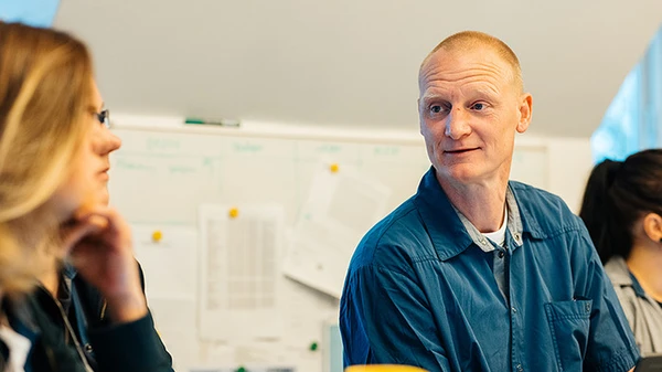 Social- og sundhedsassistent i samtale med kollega